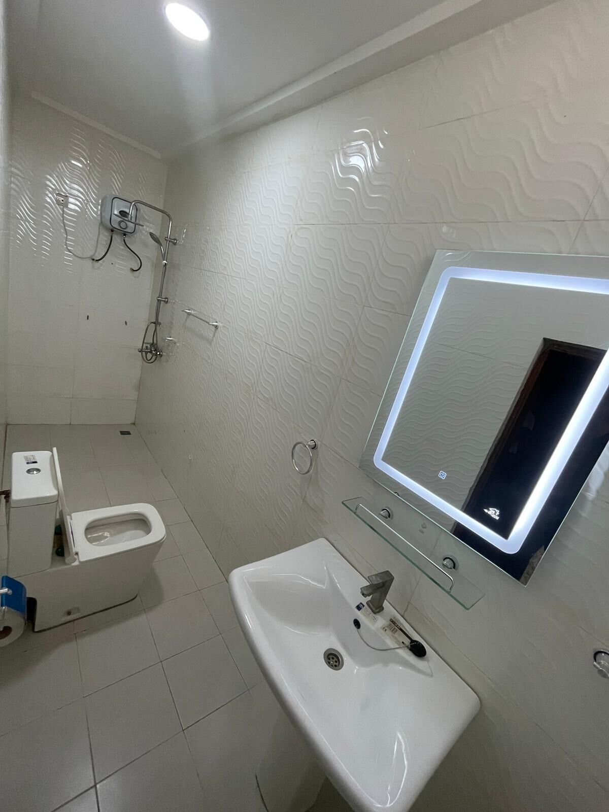 Ein modernes Badezimmer mit Toilette, Waschbecken und Dusche.