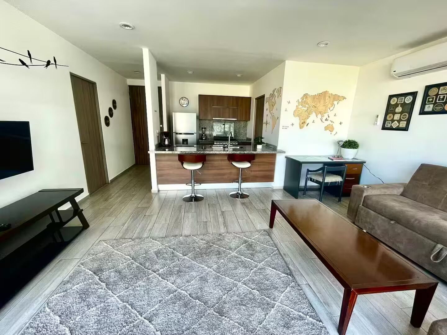 A modern living space with a kitchen, dining area, and seating.