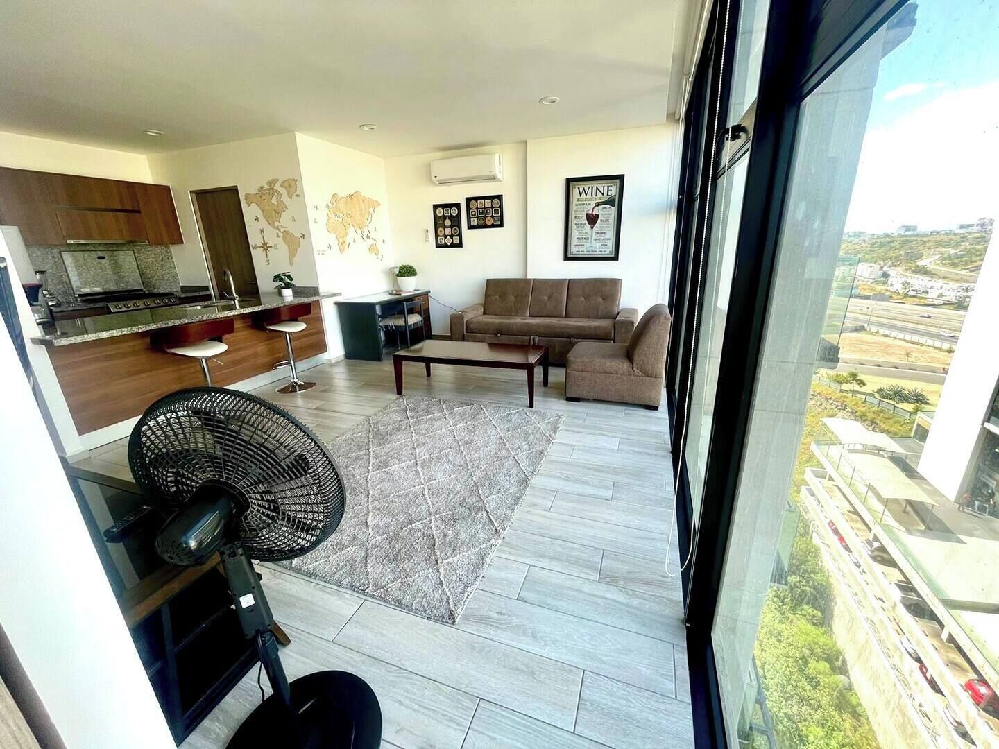 Un apartamento moderno con cocina, sala de estar y un amplio ventanal con vistas a la ciudad.