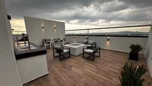 A rooftop terrace with a seating area, a small table, and a view of the cityscape. - Adorable 1-bedroom apartment in tranquil Queretaro perfect for relaxing (QUERETARO)