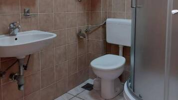 Kylpyhuone, jossa on pesuallas, wc ja suihku.