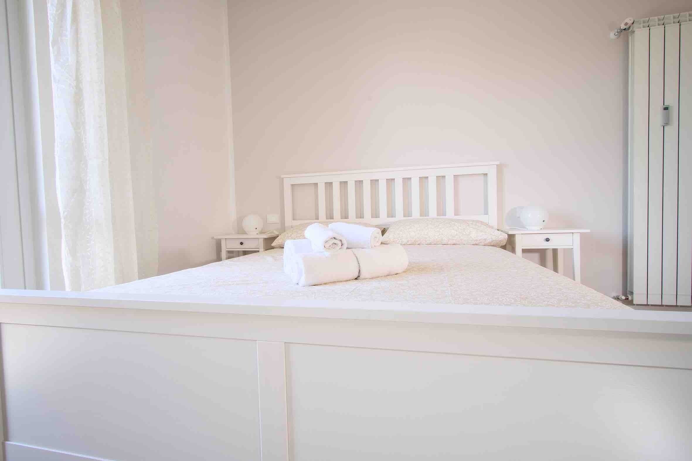 Una camera da letto con un letto, comodini e un armadio.