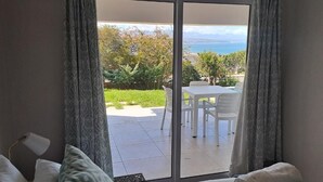 A bedroom with a sliding glass door leading to an outdoor patio with a table and chairs.