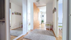 A spacious room with wooden flooring, a white wardrobe, a grey rug, and a white chair. - One bedroom apartment with panoramic view of Zagreb (Zagreb)