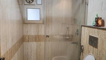 Een douche, handdoeken, zeep, shampoo