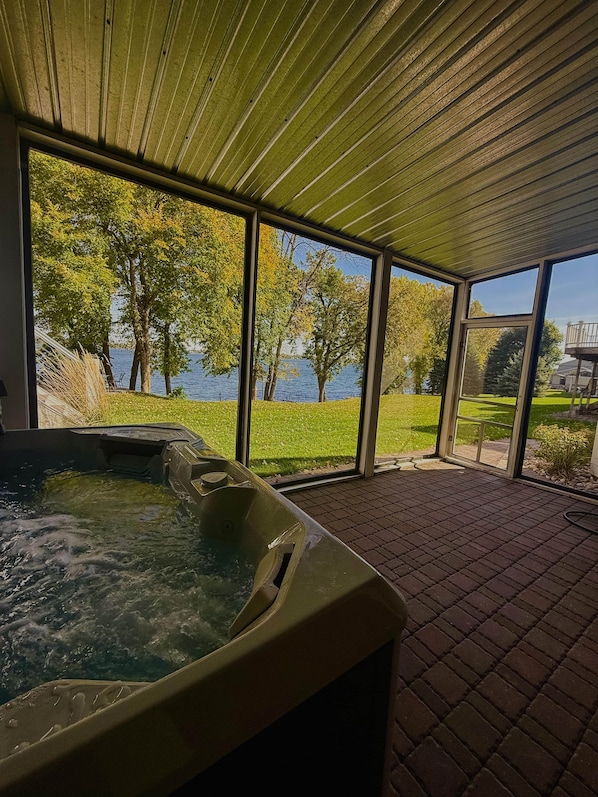 A hot tub area with a view of a lake and trees.