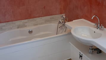 A modern bathroom with a bathtub, a sink, and a mirror.
