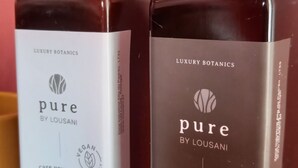 Two bottles of 'Pure by Lousani' body lotion and soap on a countertop. - Monte da Urze (Aljezur)