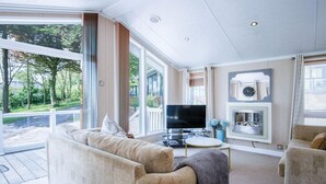 Ein geräumiges Wohnzimmer mit einer großen Couch, einem Fernseher und einem Kamin.