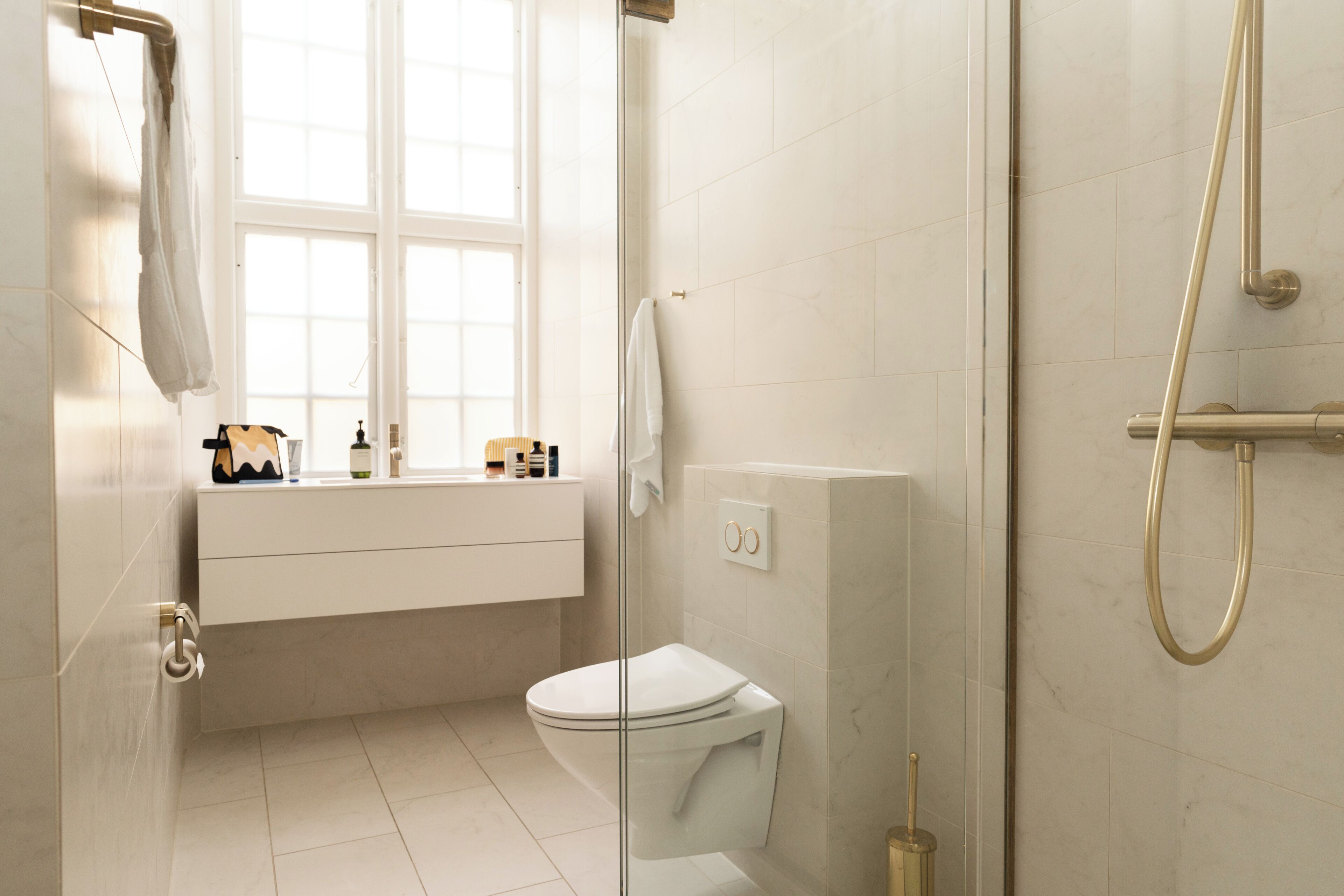 A modern bathroom with a toilet, sink, and shower.