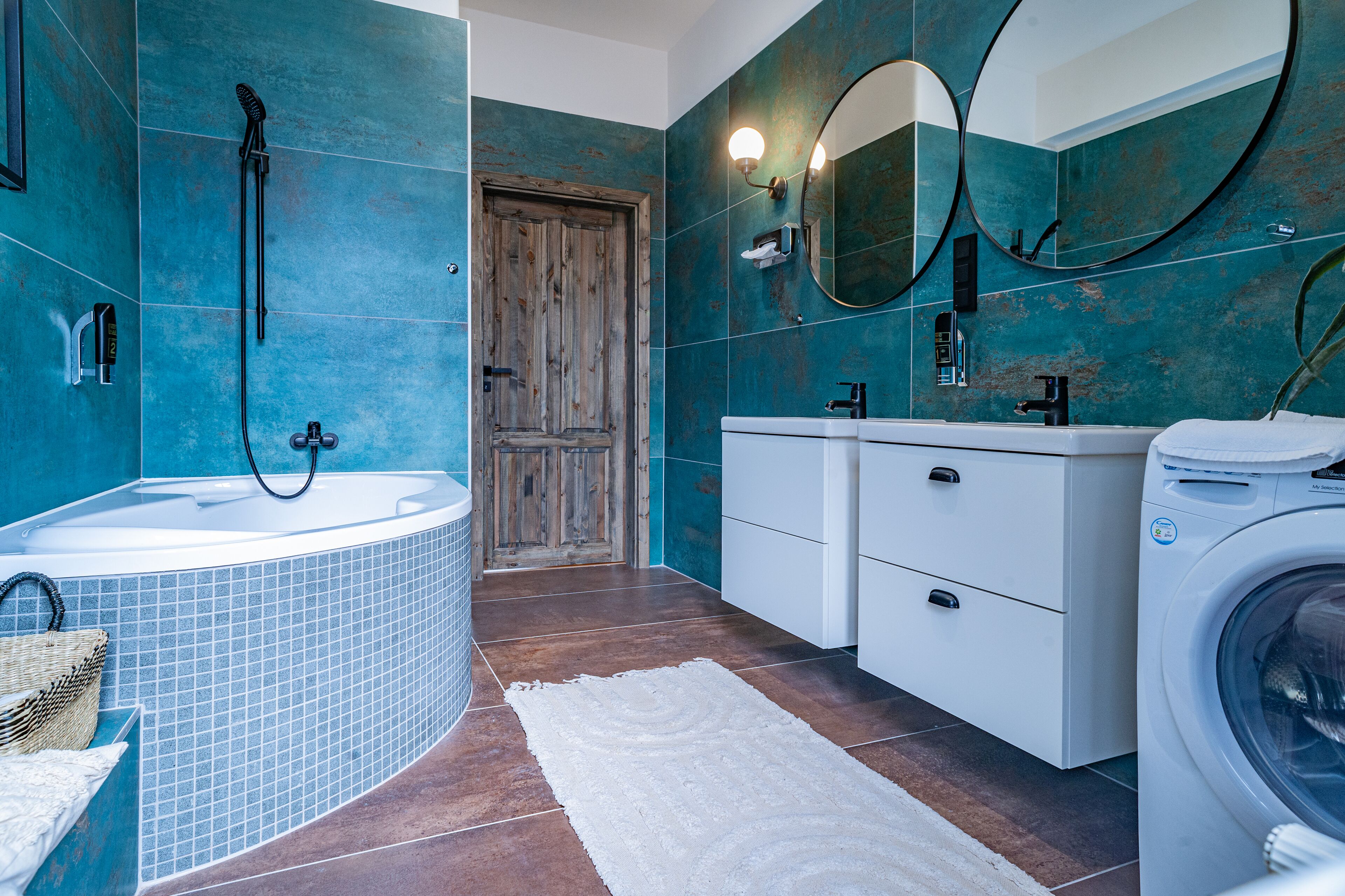 A bathroom with a bathtub, a shower, a sink, and a washing machine.