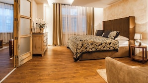 Ein Schlafzimmer mit einem großen Bett, einem Holzschrank, einem Nachttisch und einem Sessel.