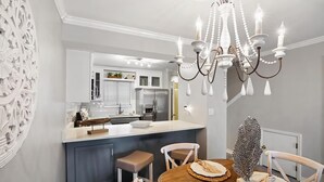 A modern kitchen with a central island, white cabinetry, and a chandelier. - Portside Sg2- Seabreeze Townhome (Panama City Beach)