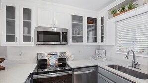 A modern kitchen with white cabinetry, stainless steel appliances, and a built-in oven. - Portside Sg2- Seabreeze Townhome (Panama City Beach)