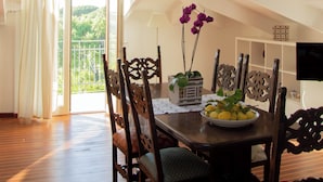 A dining area with a skylight, wooden flooring, and a table with chairs. - Comfortable Living Space in Sorrento (Sant'Agnello)