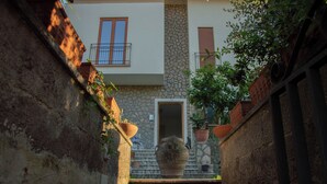 A narrow alleyway leading to a stone building with a door and steps. - Comfortable Living Space in Sorrento (Sant'Agnello)