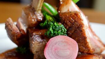 A dish with meat, vegetables, and a slice of radish on a plate.