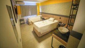 A hotel room with two beds, a small table, a sink, and a mirror. - Hotel Coroados Foz Express (Foz do Iguaçu)
