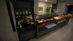 A buffet setup with various food items and beverages. - Hotel Coroados Foz Express (Foz do Iguaçu)