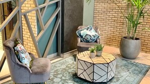 A modern interior with a grey armchair, a geometric coffee table, and a potted plant. - Nakheel Residence by House living (Sabah Al Salem)
