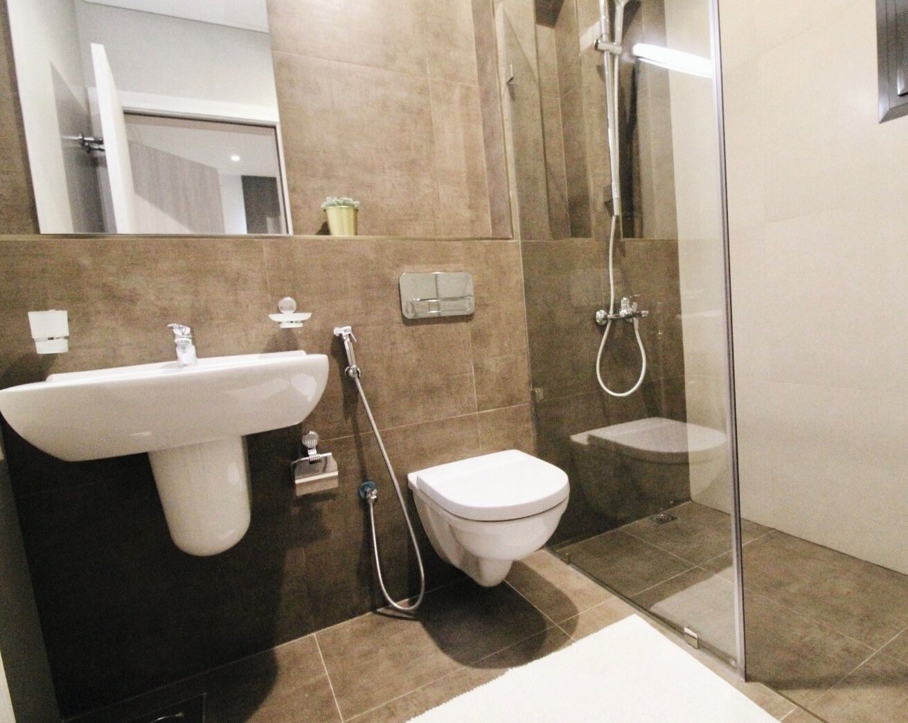 A modern bathroom with a sink, toilet, and shower.