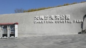Een bord voor DAMEISHA KUSTPARK met een automaat ervoor.