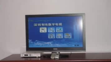 A television on a wooden cabinet with a remote control.