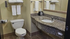 Une salle de bain équipée de toilettes, d’un lavabo et d’un porte-serviettes.