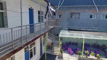 A multi-level building with a balcony, outdoor seating area, and a covered patio.