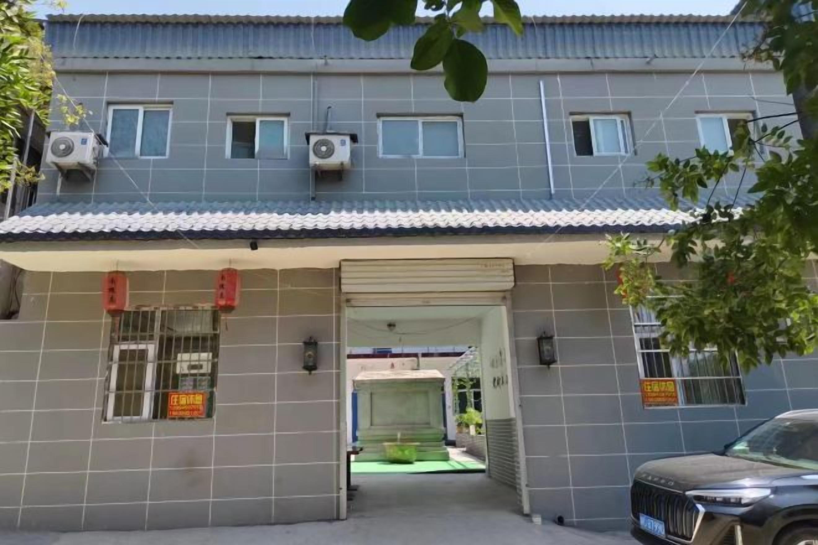 A building with a tiled facade, a covered entrance, and air conditioning units.