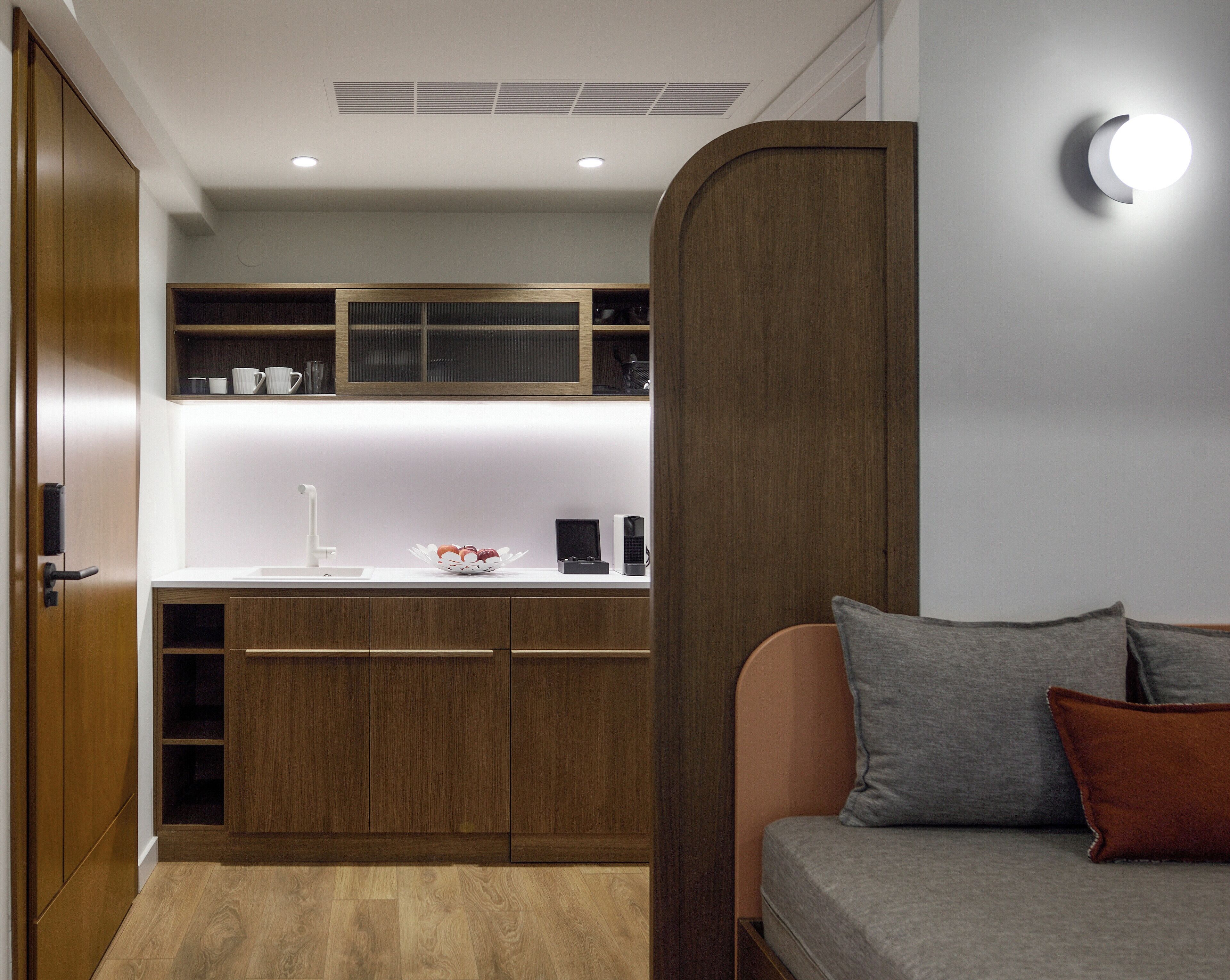 A modern kitchen with wooden cabinets, a white countertop, and a built-in oven.