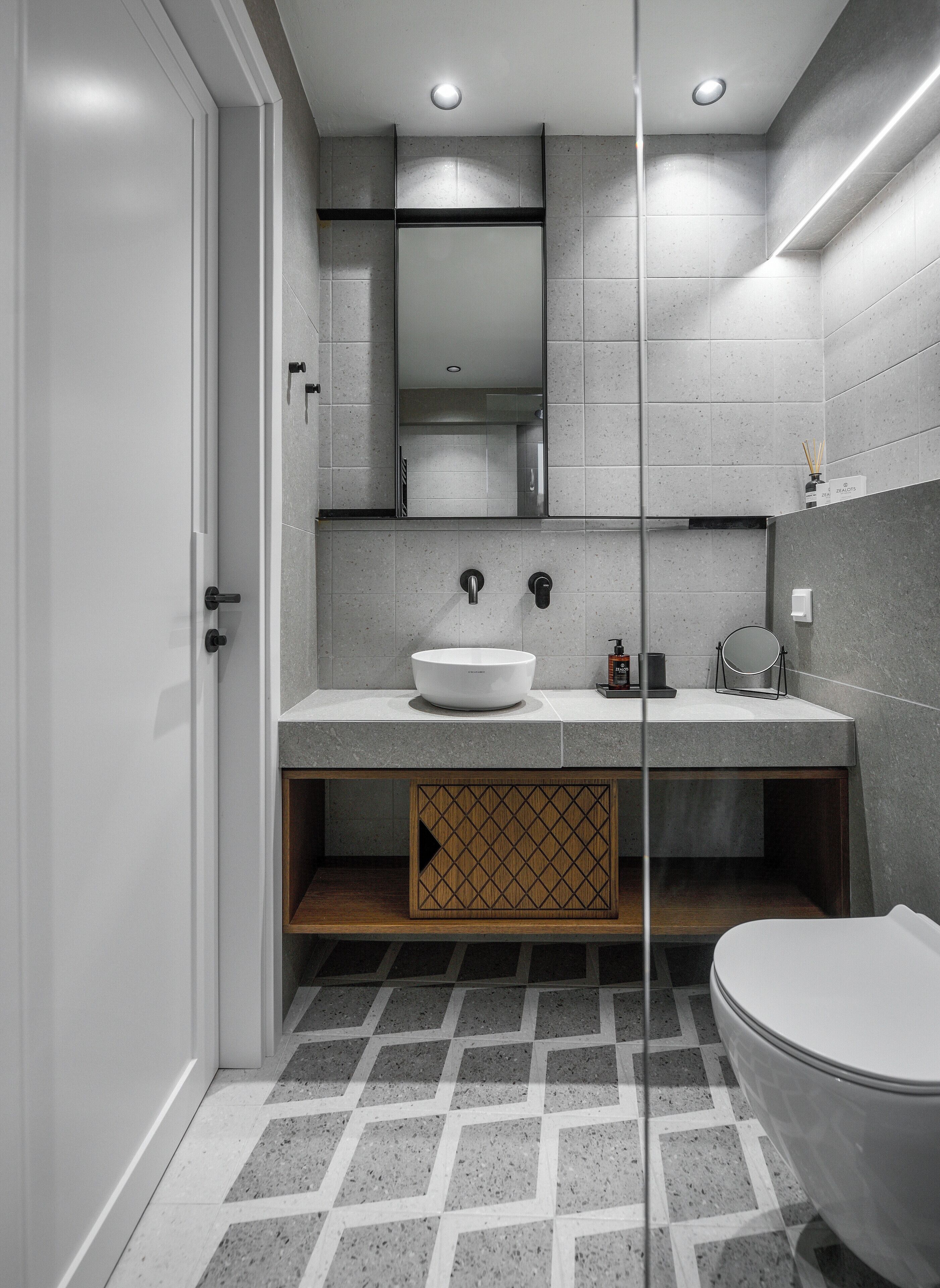 Une salle de bain moderne avec des toilettes blanches, un grand lavabo et un miroir au-dessus.