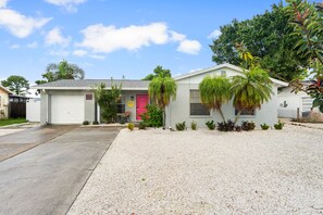 A single-story house with a garage, a front door, and a driveway. - Happy Hacienda- Heated Pool, Hot Tub, Golf, Outdoor Games (Bradenton)