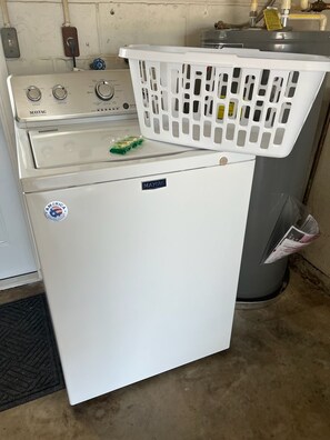 Uma unidade compacta de máquina de lavar e secar Maytag, de cor branca, com abertura frontal.