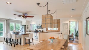 Een ruime keuken met een houten eiland, moderne apparatuur en een grote eettafel.