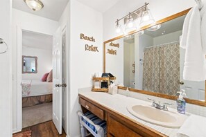 Een badkamer met een grote spiegel, een wastafel en een handdoekhouder.