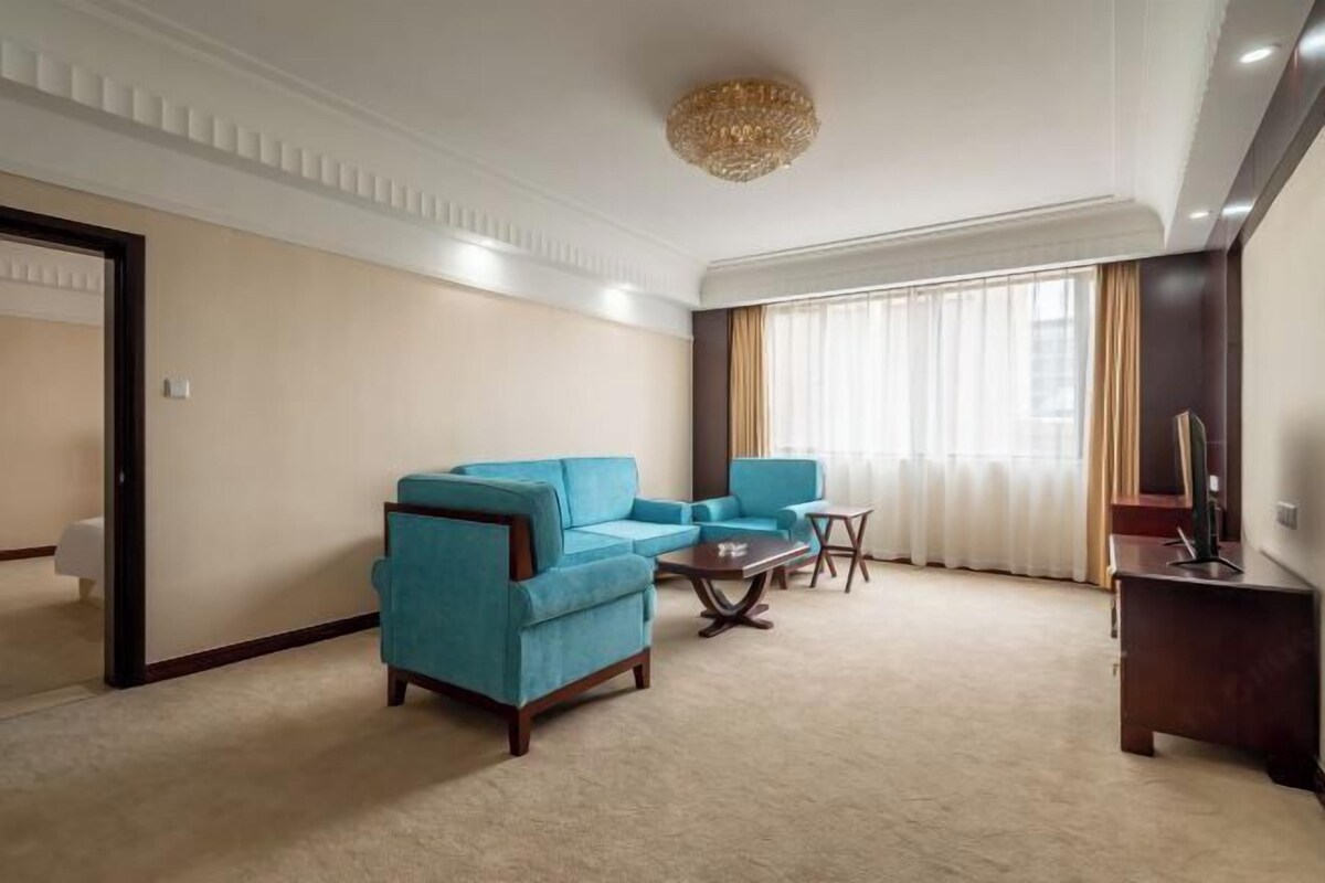 A living room with a sectional sofa, a coffee table, and a TV stand.