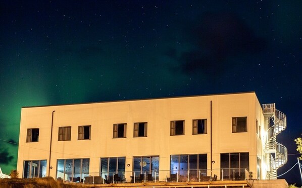 A modern building with a flat facade, multiple windows, and a staircase on the right side. - The Tide - Hotel (Moskenes)