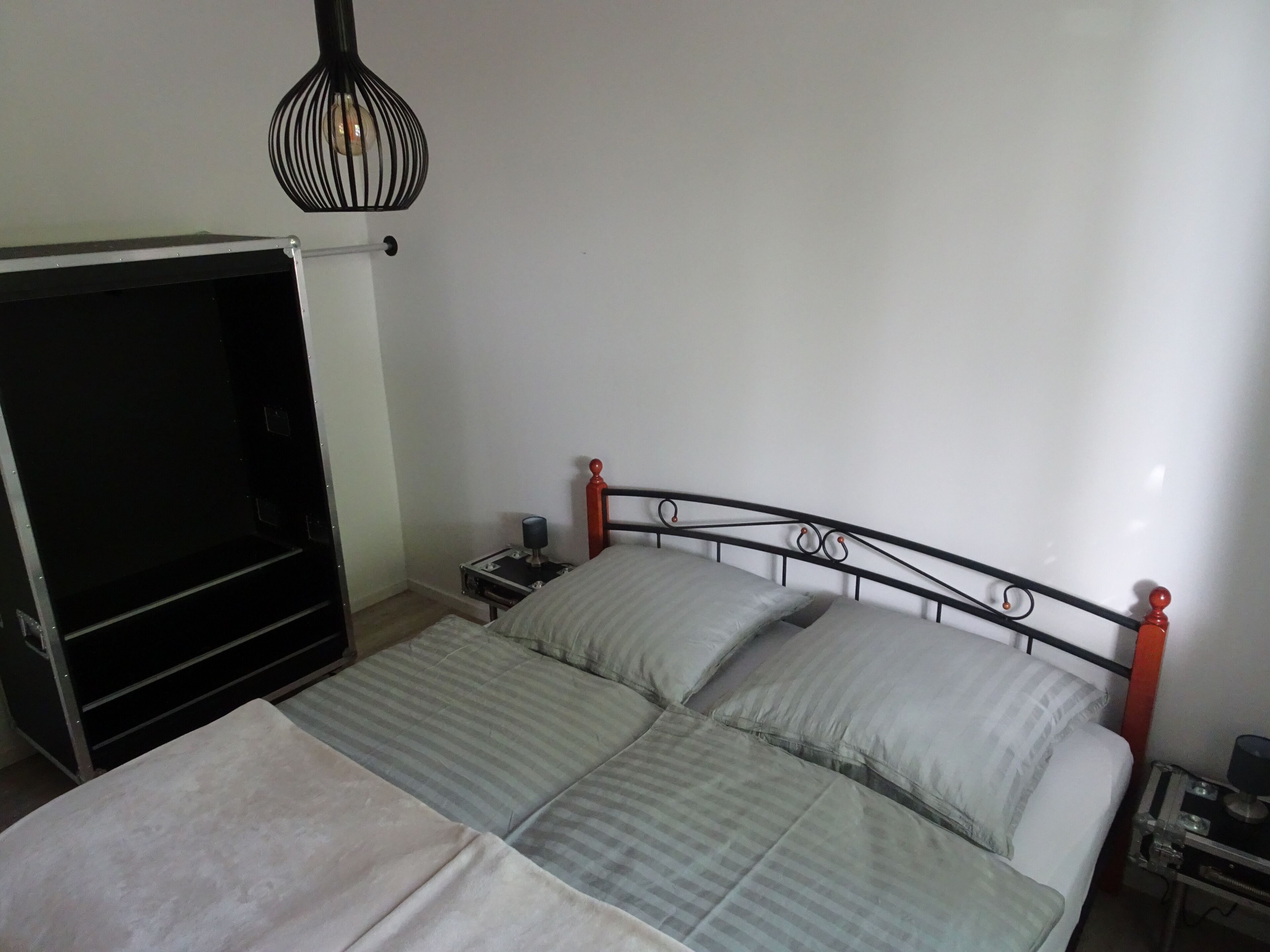 Une chambre à coucher avec un lit, une table de chevet, une lampe et un meuble pour la télévision.