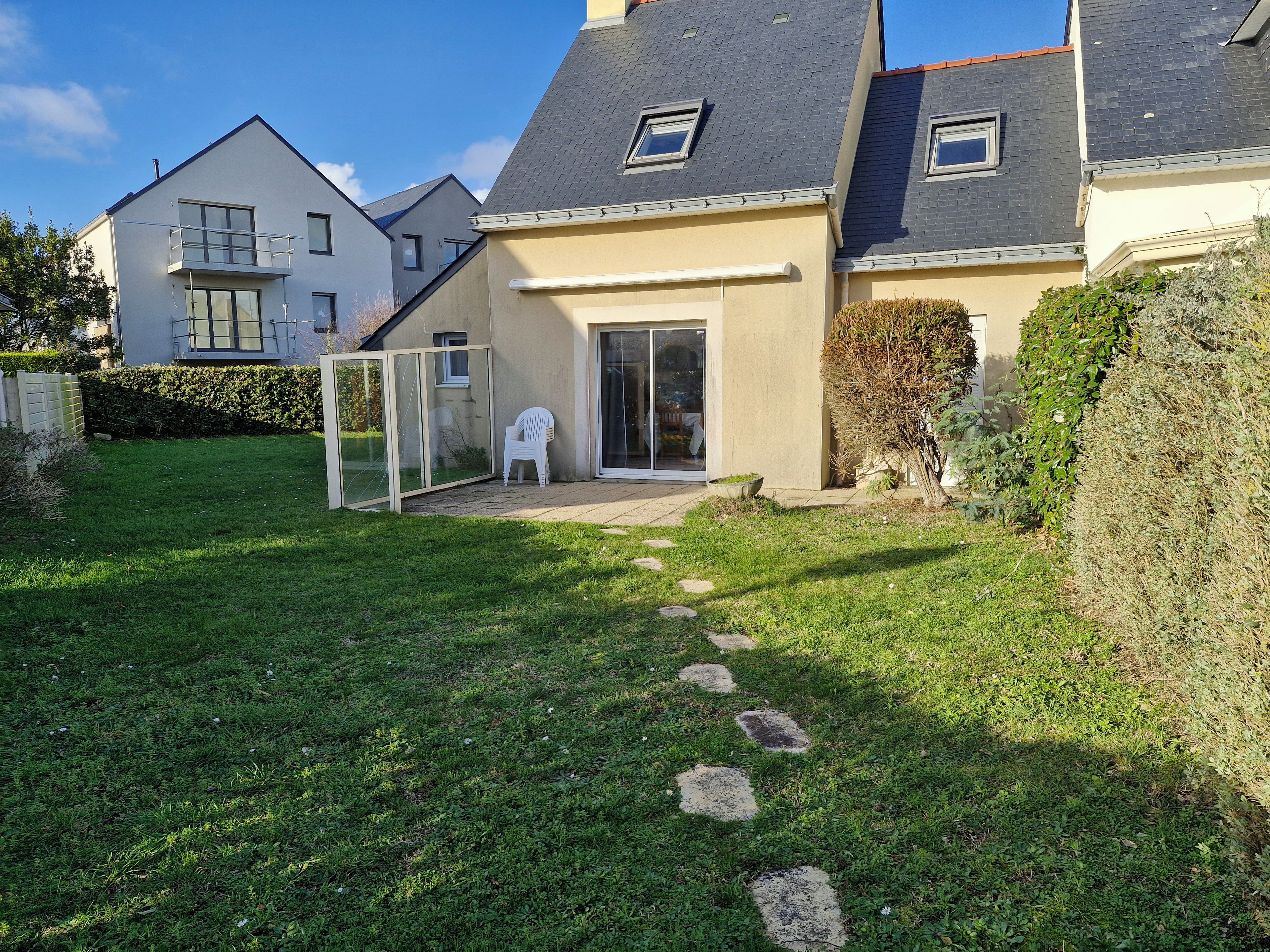 A residential property with a well-maintained lawn, a patio area, and a sliding glass door entrance.