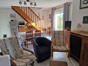 Uma sala de estar com lareira, uma sala de jantar e uma cozinha.