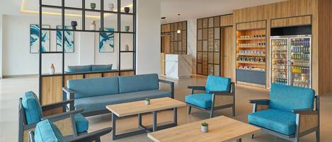 A modern lounge area with seating, a coffee table, and a decorative wall with shelves.