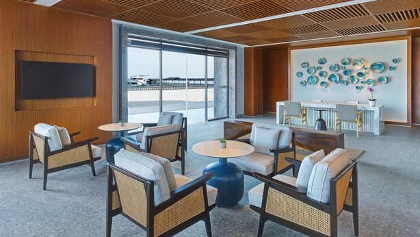 A spacious lobby with wicker furniture, a large TV, and a wall decorated with blue ceramic pieces. - Fairfield By Marriott Kuala Besut (Kampong Raja)