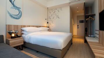 A modern bedroom with a large bed, bedside tables, a wall art piece, and a wardrobe.