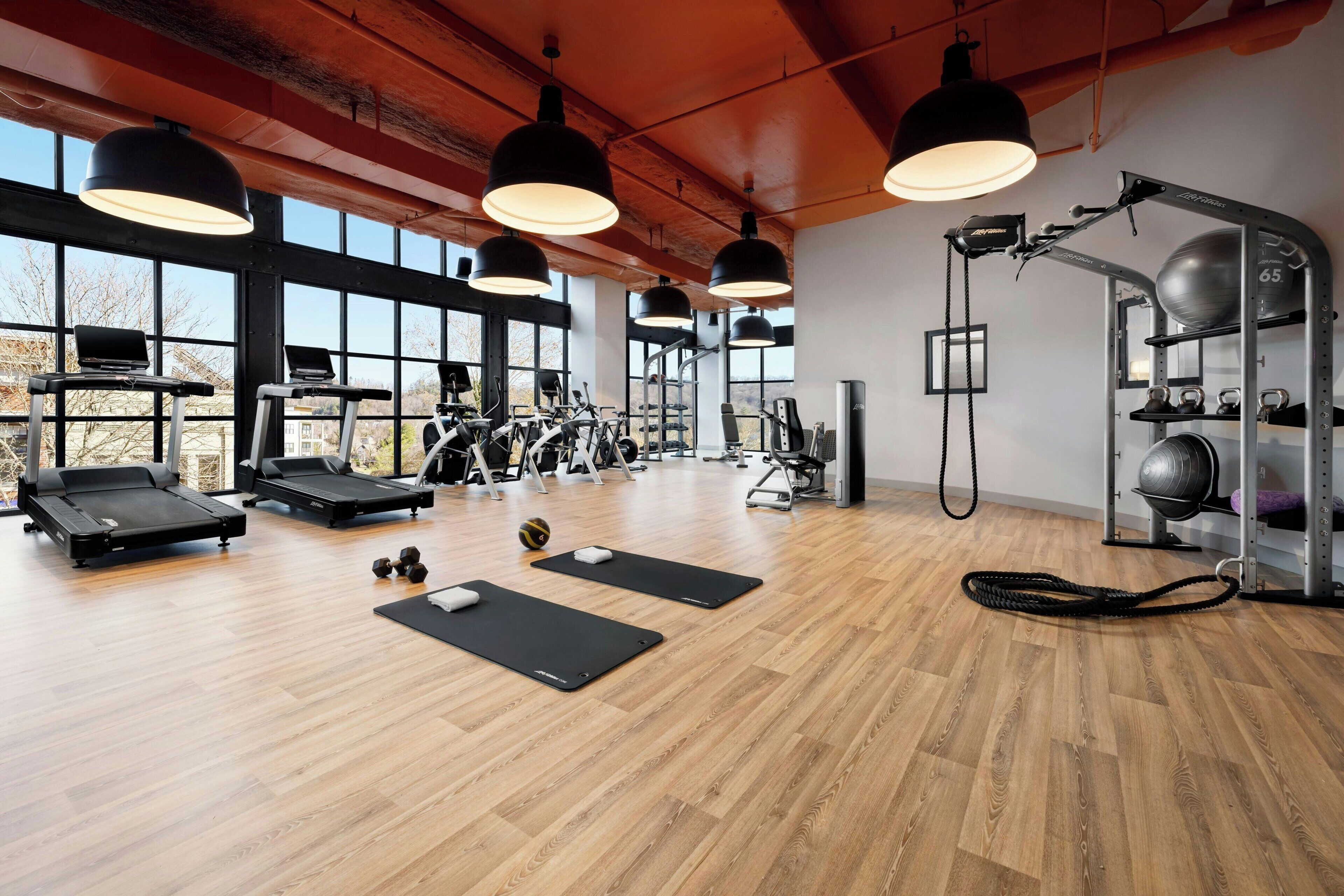 A gym with treadmills, exercise balls, and weight equipment.
