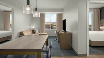 Une chambre d’hôtel équipée d’un lit, d’un bureau, d’une chaise, d’une table et d’un téléviseur.