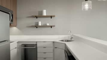 A modern kitchen with white countertops, stainless steel appliances, and wooden shelves.
