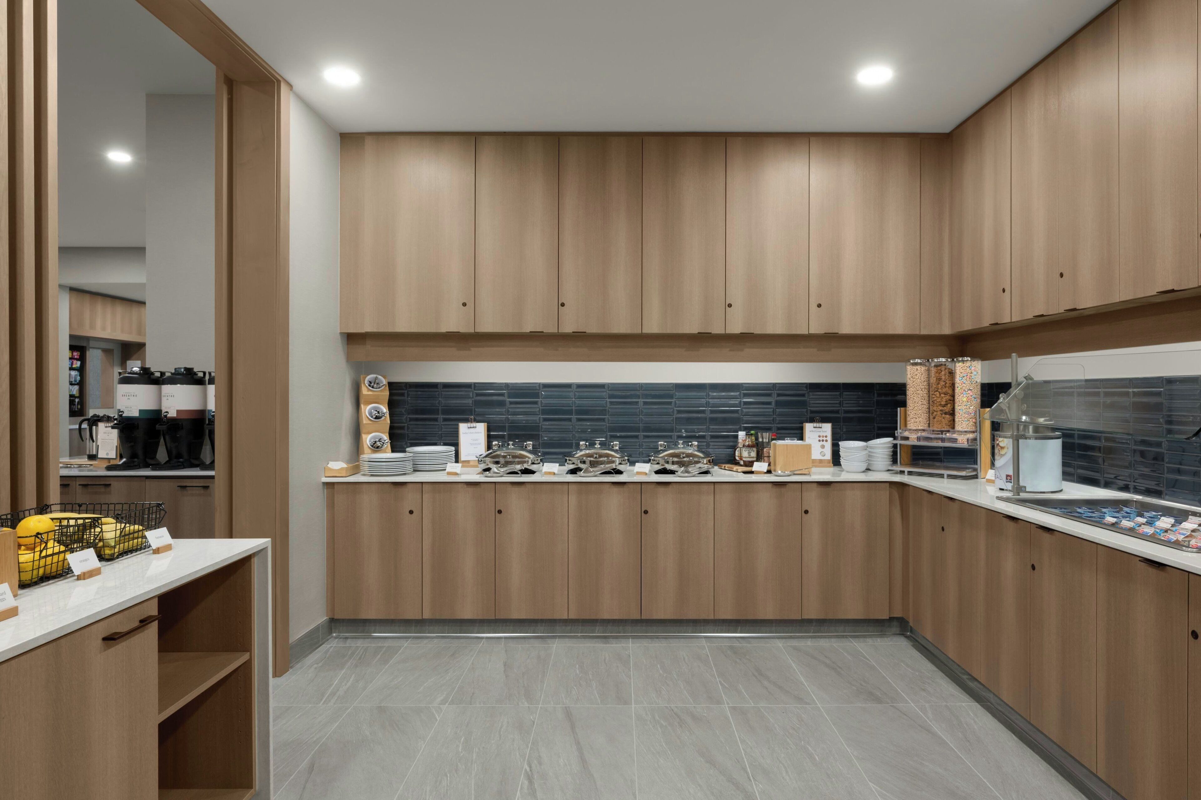 A modern kitchen with wooden cabinets, a tiled backsplash, and a breakfast bar.