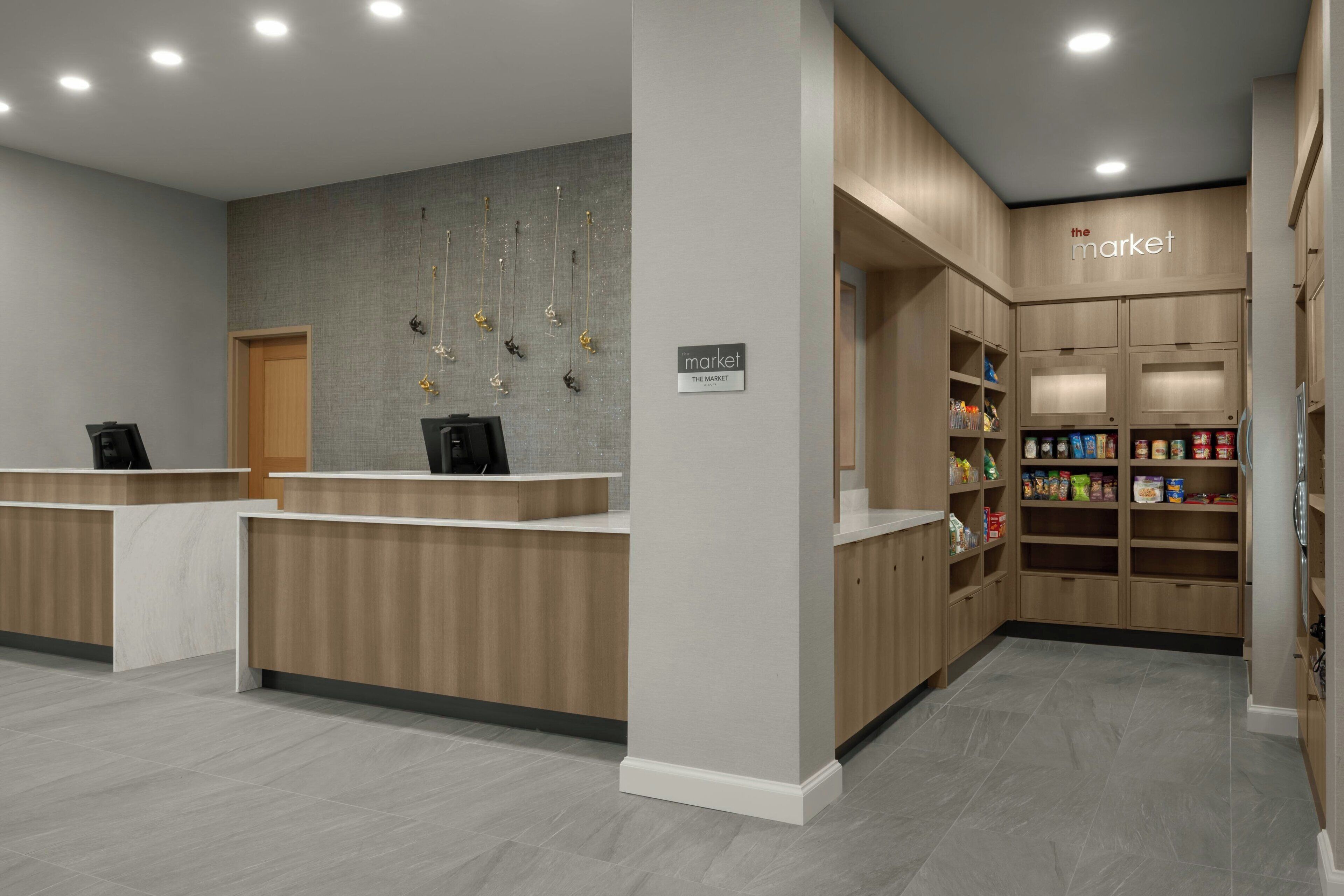 A reception area with a wooden reception desk, a wall-mounted coat rack, and a shelf stocked with snacks.
