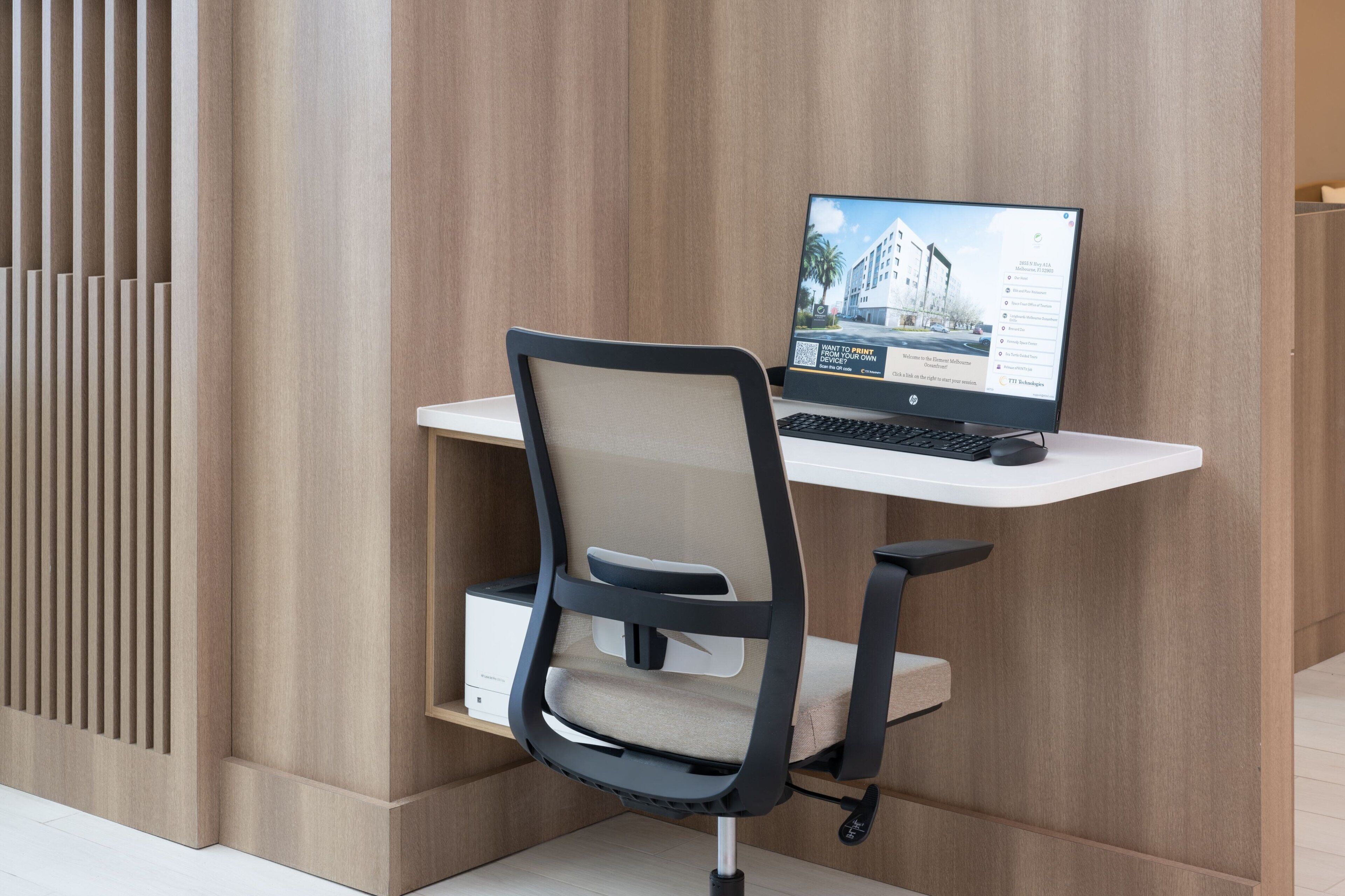 A modern office desk with a laptop, a chair, and a white shelf.